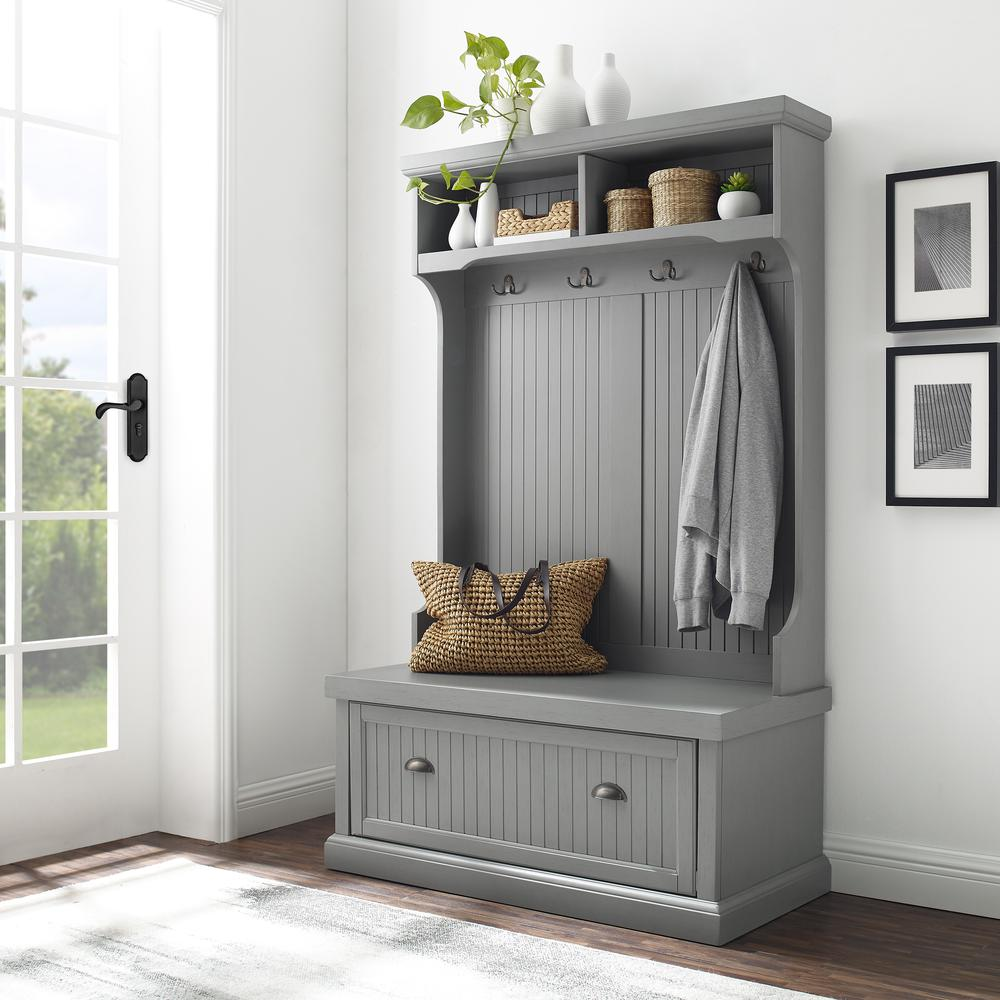 Bright doorway view of an entryway storage rack in gray color showing storage cubicles and coat rack 